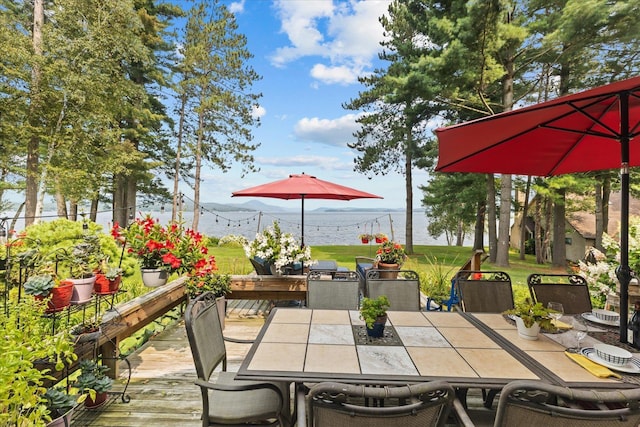 deck with outdoor dining space and a yard