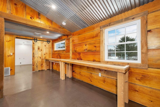 interior space with finished concrete flooring, wooden walls, visible vents, wooden ceiling, and a sauna