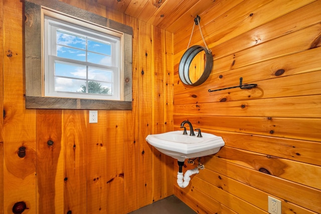 bathroom featuring wood walls, a sink, and wood ceiling