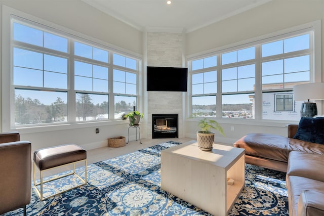 living area with a large fireplace, baseboards, ornamental molding, and recessed lighting