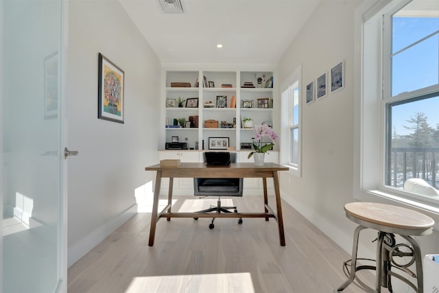 office space with a wealth of natural light, visible vents, and light wood-style flooring