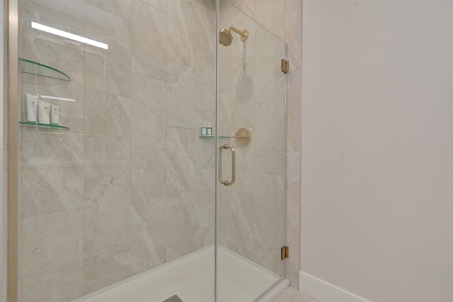 full bath featuring a stall shower and baseboards