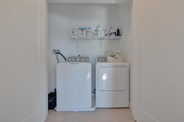 laundry area featuring light wood finished floors, laundry area, and washing machine and clothes dryer