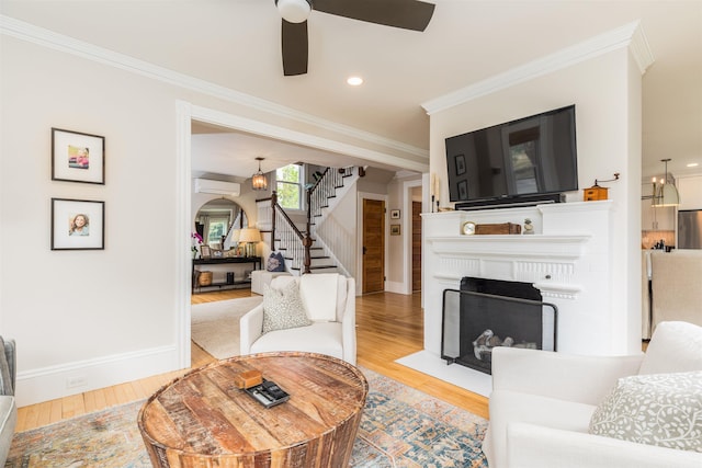 living room featuring ornamental molding, stairway, light wood-style flooring, and baseboards