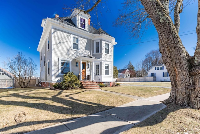 view of front facade with fence and a front yard