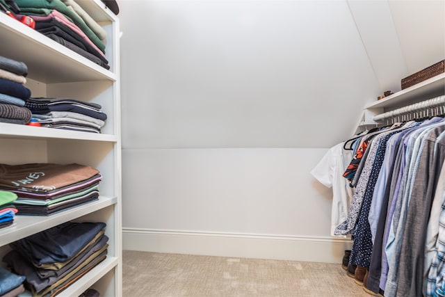 walk in closet with carpet floors and vaulted ceiling