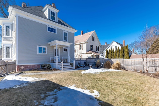 rear view of house with a yard and fence