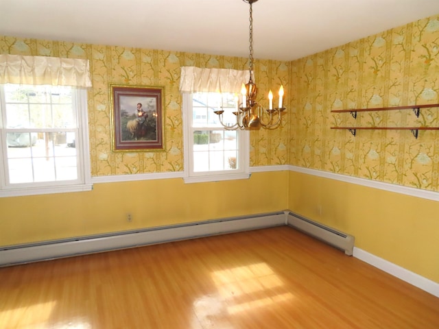 unfurnished room with wallpapered walls, plenty of natural light, and wood finished floors