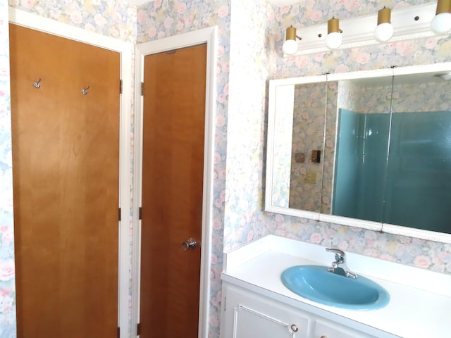 bathroom featuring wallpapered walls and vanity