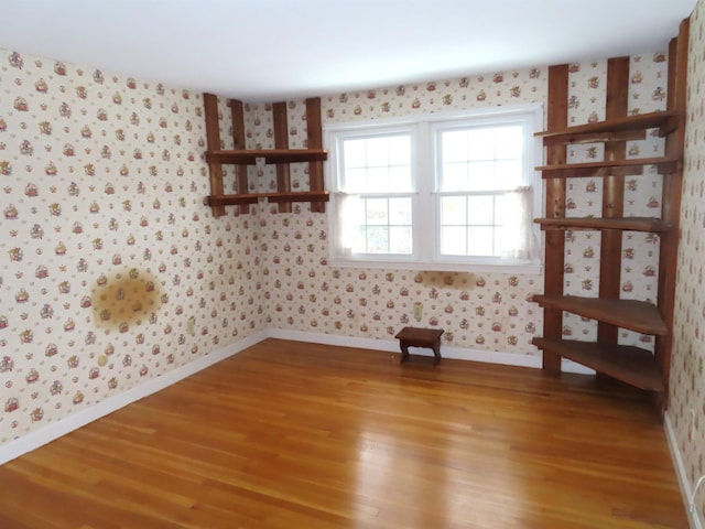 unfurnished room with baseboards, light wood-style flooring, and wallpapered walls