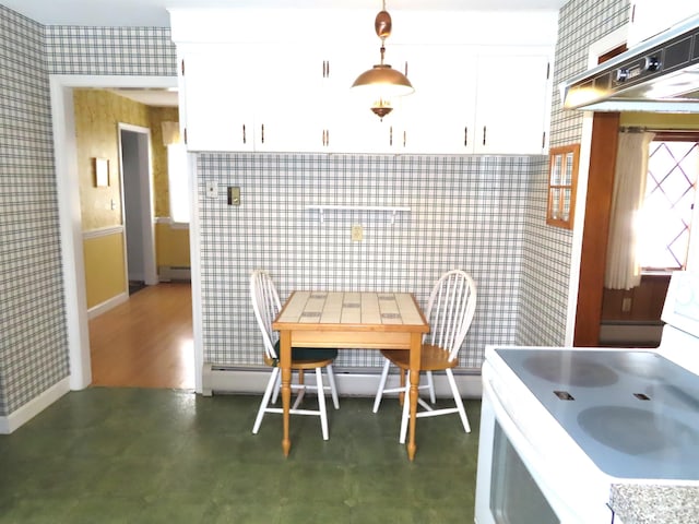 kitchen featuring wallpapered walls, white cabinets, decorative light fixtures, under cabinet range hood, and white range with electric cooktop