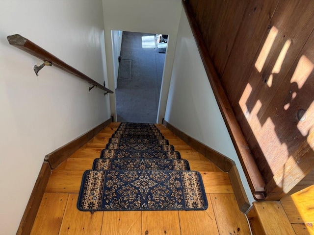 staircase featuring baseboards and wood finished floors