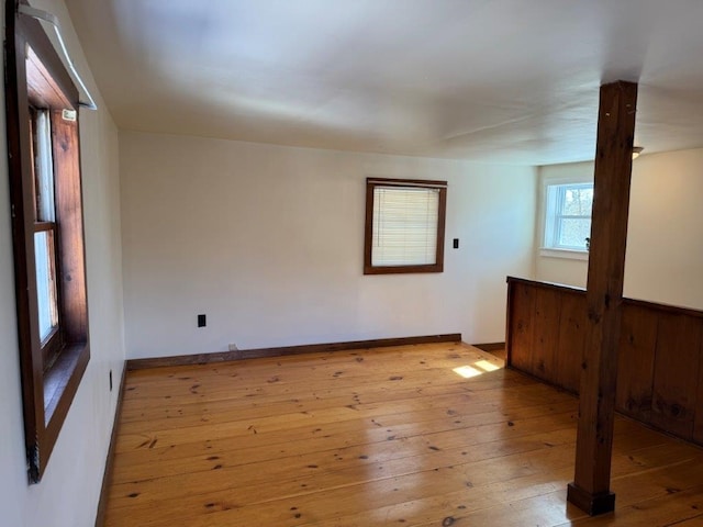 empty room featuring baseboards and light wood finished floors