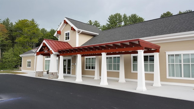 rear view of property featuring a shingled roof, a standing seam roof, and metal roof