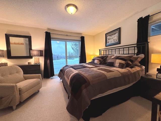 bedroom with carpet floors, access to exterior, and a textured ceiling