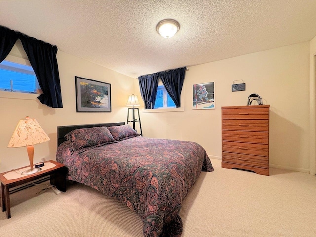 bedroom with carpet, baseboards, and a textured ceiling