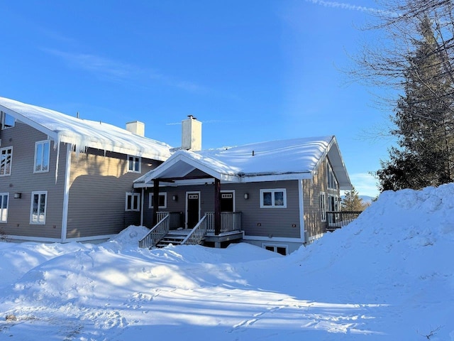 snow covered property featuring a chimney