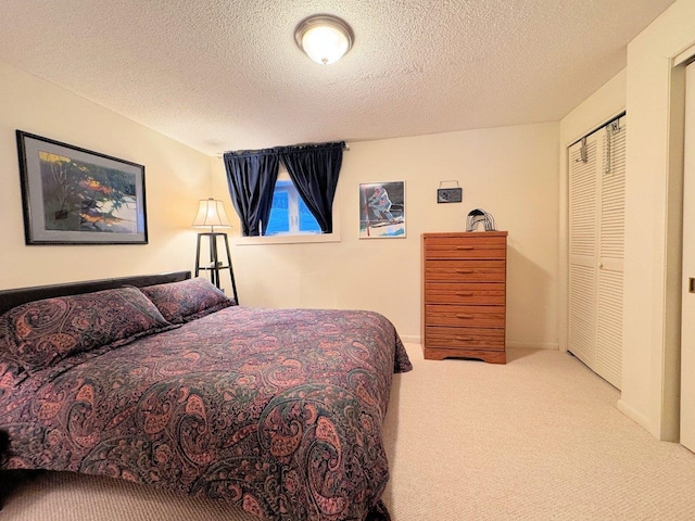 carpeted bedroom with a textured ceiling and a closet