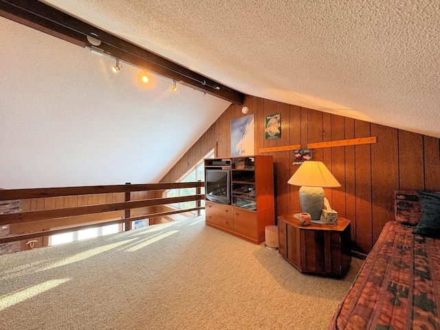 bonus room featuring a textured ceiling, wooden walls, vaulted ceiling, and carpet flooring