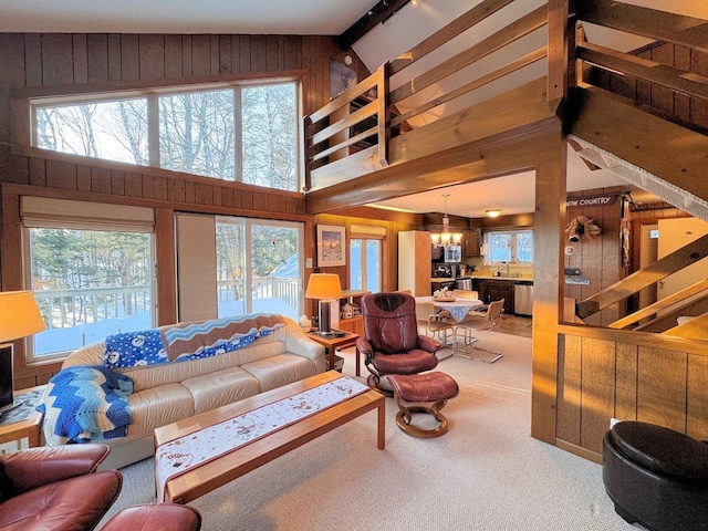 living room with a healthy amount of sunlight, wood walls, and carpet