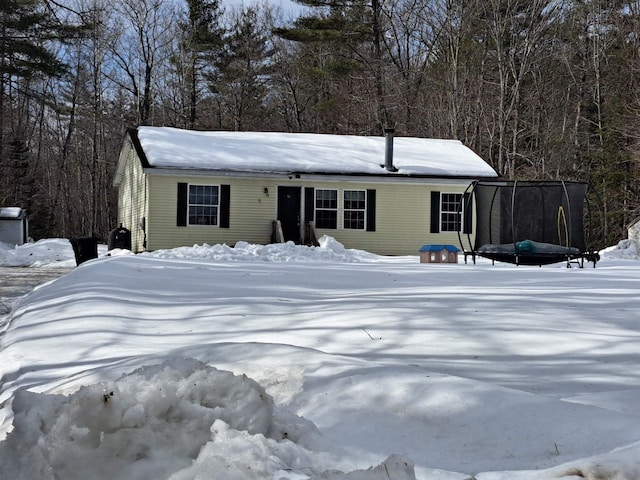 view of front of property featuring a forest view and a trampoline