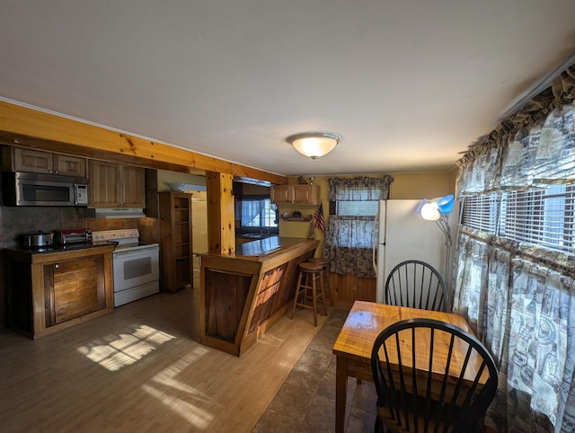 kitchen featuring white appliances, light wood-style flooring, and under cabinet range hood