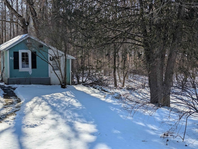 snowy yard featuring an outbuilding