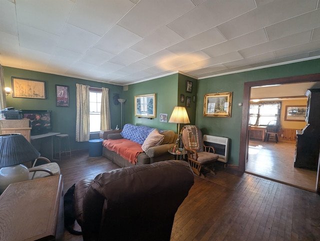 living room with heating unit, hardwood / wood-style flooring, and a wealth of natural light