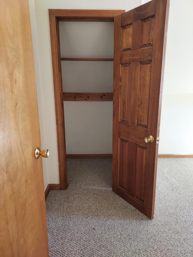 corridor featuring carpet and baseboards