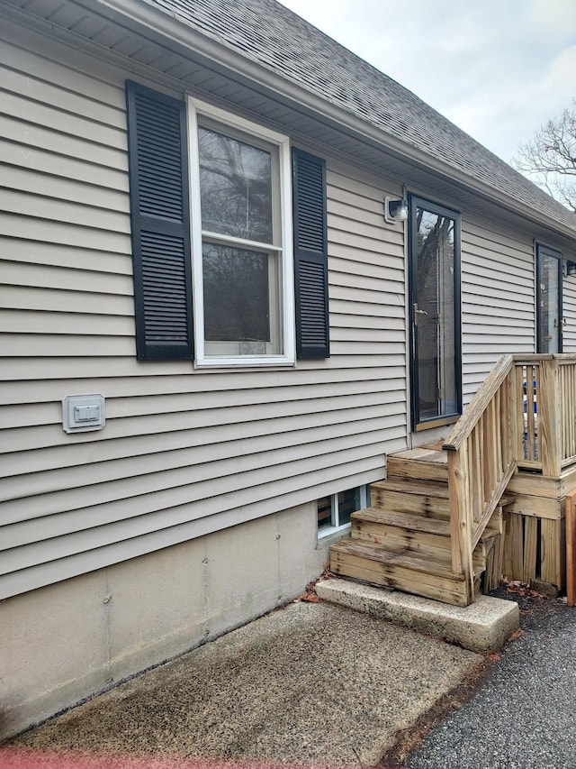 doorway to property with a shingled roof