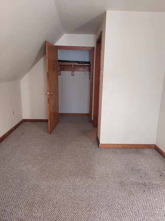 bonus room with light carpet, baseboards, and lofted ceiling