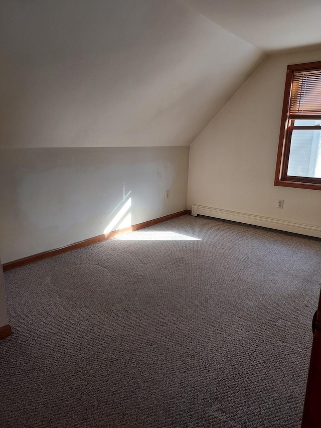 additional living space with lofted ceiling, a baseboard radiator, baseboards, and carpet flooring