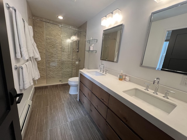 bathroom featuring a sink, baseboard heating, a stall shower, and double vanity