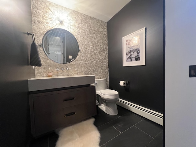 bathroom with vanity, baseboards, a baseboard radiator, tile patterned flooring, and toilet