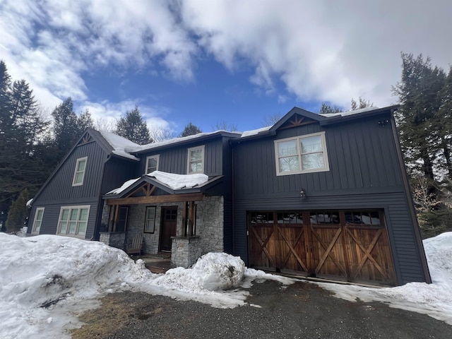 view of front of home featuring stone siding, board and batten siding, and an attached garage