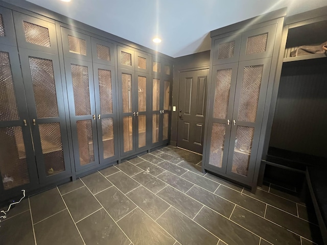 mudroom with dark tile patterned floors