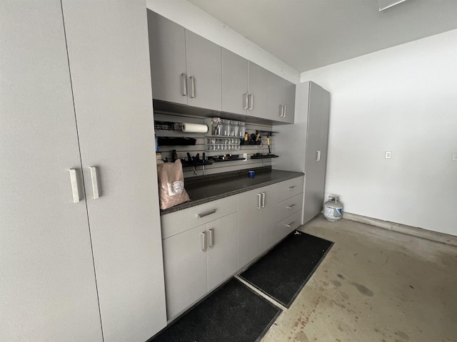 kitchen featuring dark countertops, concrete flooring, and gray cabinets