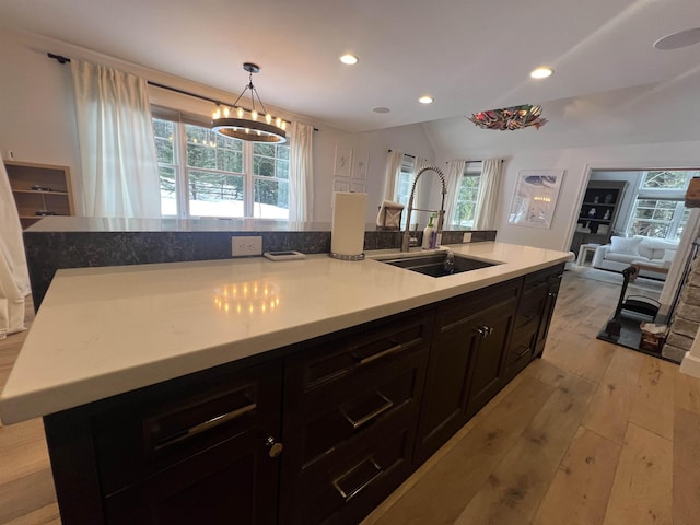 kitchen with a sink, a wealth of natural light, and light wood-style flooring