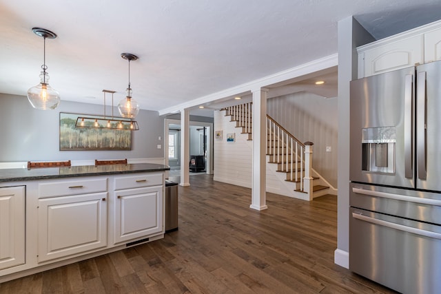 kitchen with dark stone countertops, dark wood-type flooring, decorative light fixtures, white cabinetry, and stainless steel refrigerator with ice dispenser