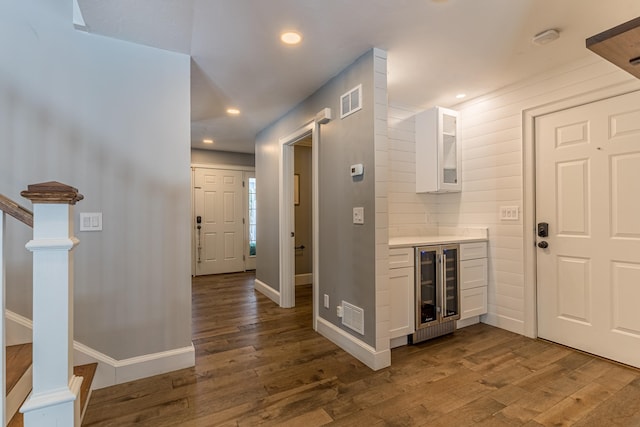 foyer with dark wood-type flooring, visible vents, and recessed lighting