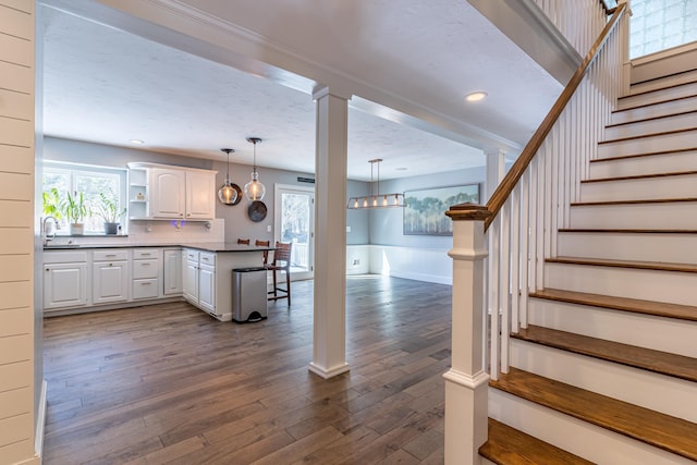 kitchen with dark wood-style flooring, a healthy amount of sunlight, a peninsula, and open shelves