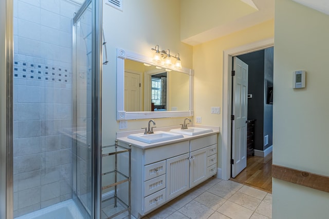 full bathroom featuring double vanity, a sink, visible vents, and a shower stall