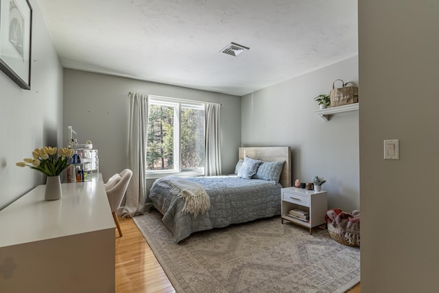 bedroom featuring light wood finished floors and visible vents