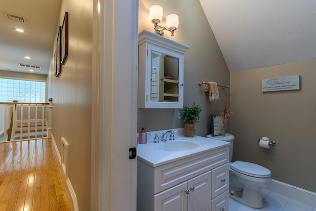 bathroom with toilet, lofted ceiling, visible vents, and vanity