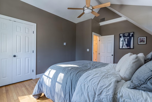 bedroom with lofted ceiling, ceiling fan, visible vents, a closet, and light wood-type flooring