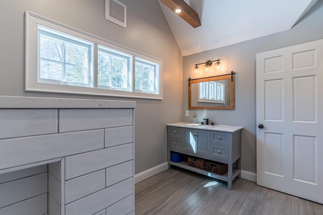 bathroom featuring vaulted ceiling, baseboards, and wood finished floors