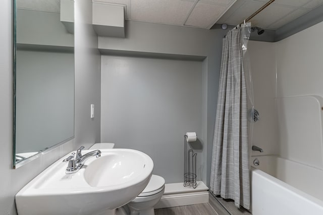 full bathroom with toilet, shower / bathtub combination with curtain, a sink, and wood finished floors