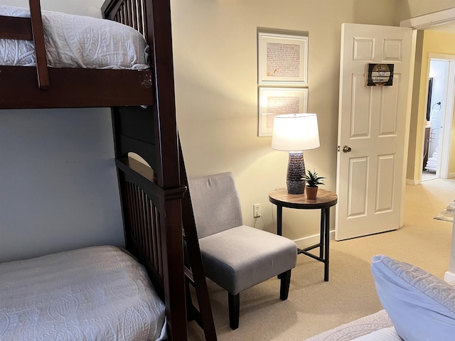 bedroom with light colored carpet and baseboards