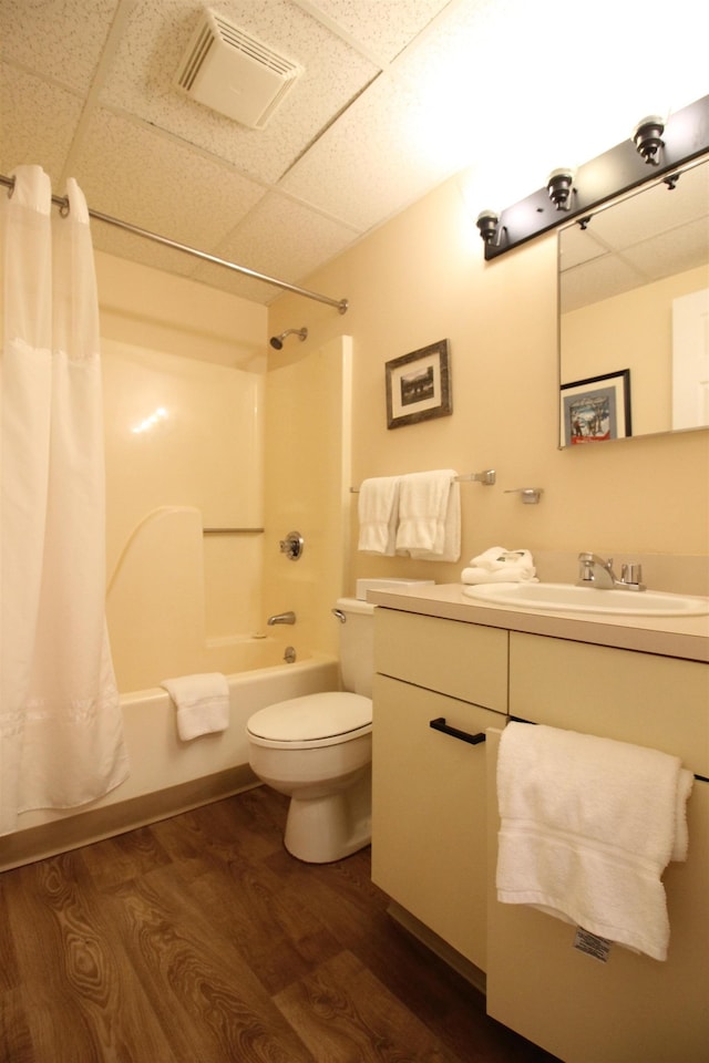 full bathroom with visible vents, toilet, wood finished floors, shower / tub combo with curtain, and vanity