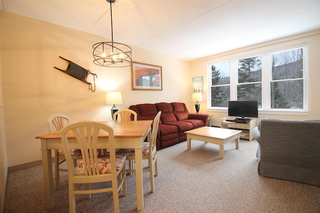 living room featuring carpet, an inviting chandelier, and baseboards